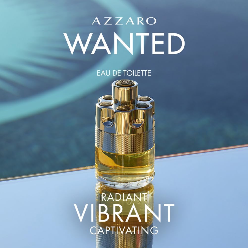 Azzaro Wanted perfume bottle on a reflective surface with a blurred natural background