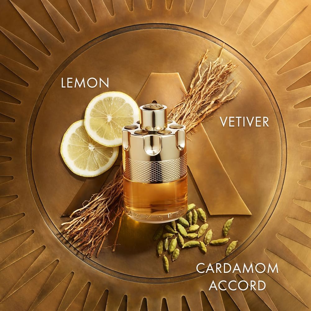 Perfume bottle with lemon slices, vetiver grass, and cardamom seeds on a gold background