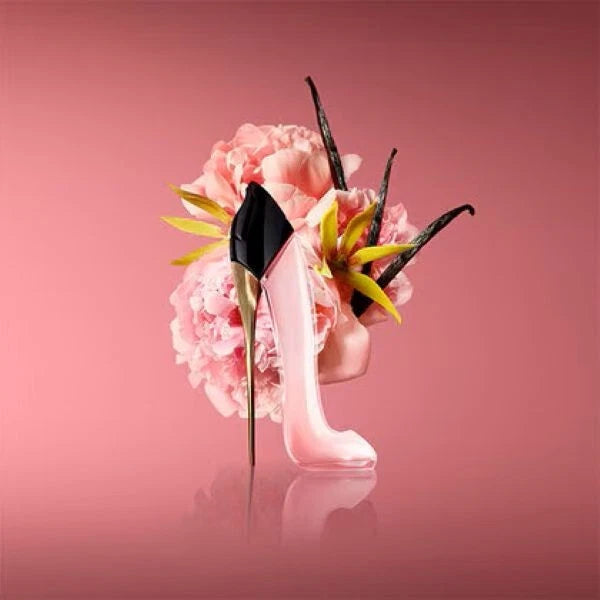 High-heeled shoe with pink flowers and vanilla beans on a pink background