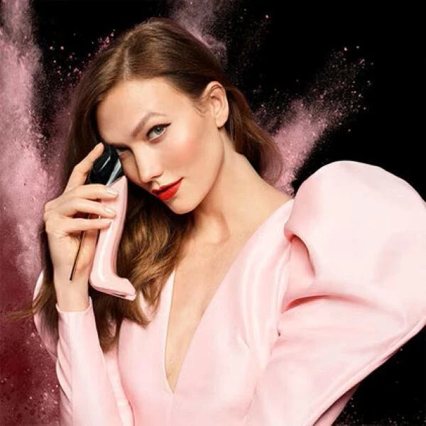 Woman in a pink outfit with a black background
